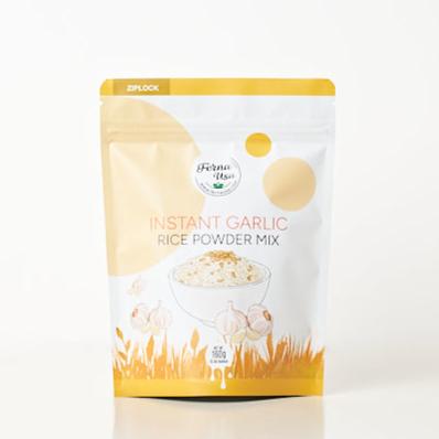 160 grams stand-up pouch packaging with zip lock of FERNA USA Instant Garlic Rice Powder Mix. The front displays an illustration of a bowl of rice with toasted garlic toppings. Visible colors are yellow, brown and white.